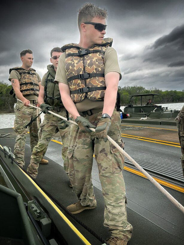 U.S. Army Reserve Soldiers from the 401st Engineer Company conduct multi-role bridging training operations at Bardwell Lake in Texas. The exercise focuses on wet gap crossing techniques, including ribbon bridge and raft operations, enabling the transport of vehicles, equipment, and personnel across water obstacles. The training integrates new Soldiers fresh from Advanced Individual Training (AIT) alongside experienced Noncommissioned Officers, enhancing readiness, morale, and technical proficiency. Conducted in partnership with the U.S. Army Corps of Engineers (USACE), the field training exercise highlights the importance of interagency collaboration and access to USACE-managed resources for realistic, mission-essential training environments.