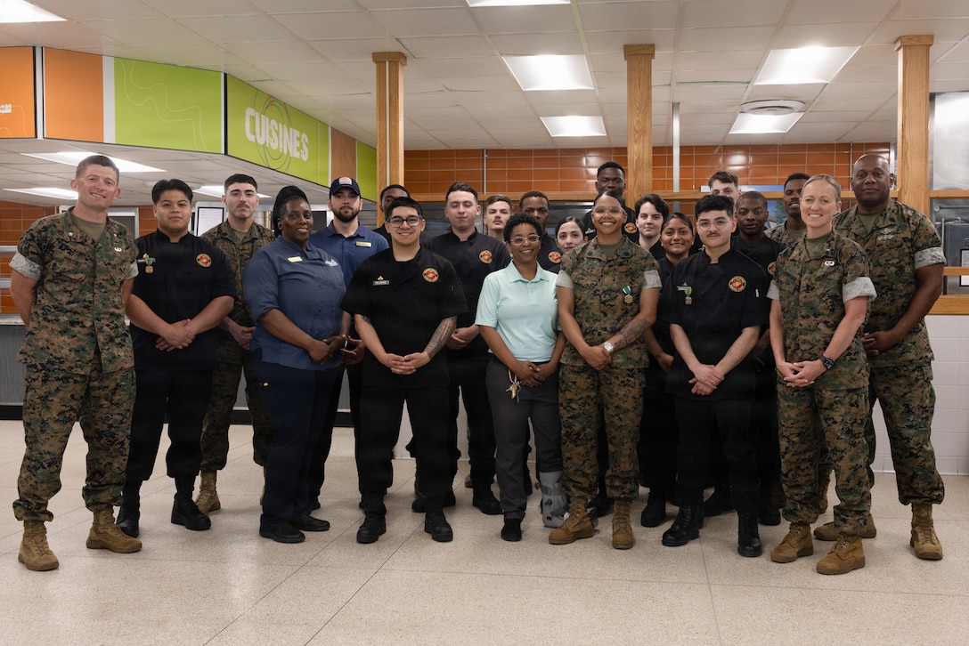 U.S. Marines, Sailors, and mess hall attendants pose for photo after an award ceremony at Marine Corps Base Camp Lejeune, North Carolina, April 6, 2026. The mess hall attendants earned the Major General W.P.T. Hill Memorial Award for “Best Management and Mess Attendant Mess Hall” in recognition of their professionalism, commitment, and expertise, which have brought great credit upon themselves, the Installations and Logistics mission, the food service community, and the Marine Corps. (U.S. Marine Corps photo by Lance Cpl. Talan Werner)