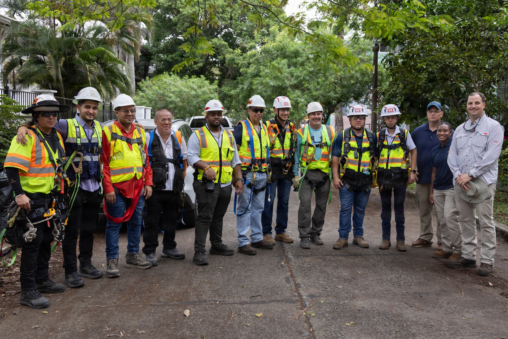 A group of workers with reflective vests and hard hats pose for a photo.