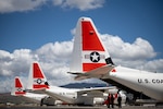 Three U.S. Coast Guard HC-130J Hercules aircraft parked on the flightline at Air Station Barbers Point, Oahu, Hawaii.