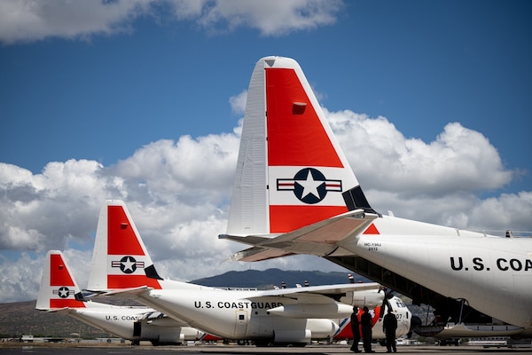 Three U.S. Coast Guard HC-130J Hercules aircraft parked on the flightline at Air Station Barbers Point, Oahu, Hawaii.