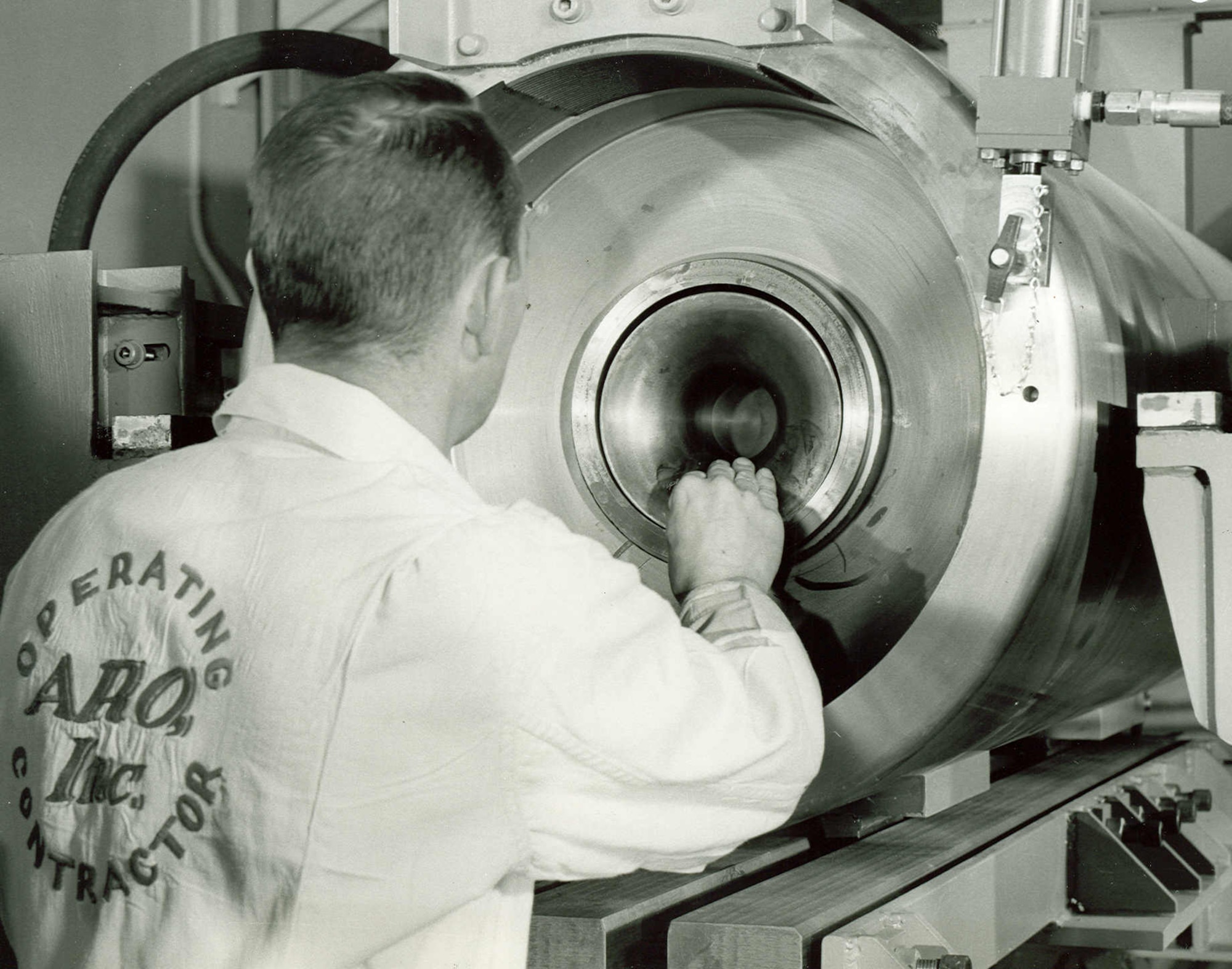 An Arnold Research Organization technician inserts a projectile encased in a launching sabot into the Range G High Impact Ballistic Testing Facility at Arnold Engineering Development Center in 1963. ARO was the first company awarded a contract to operate AEDC. The contract between ARO and the Air Force was signed June 29, 1950. (U.S. Air Force photo)