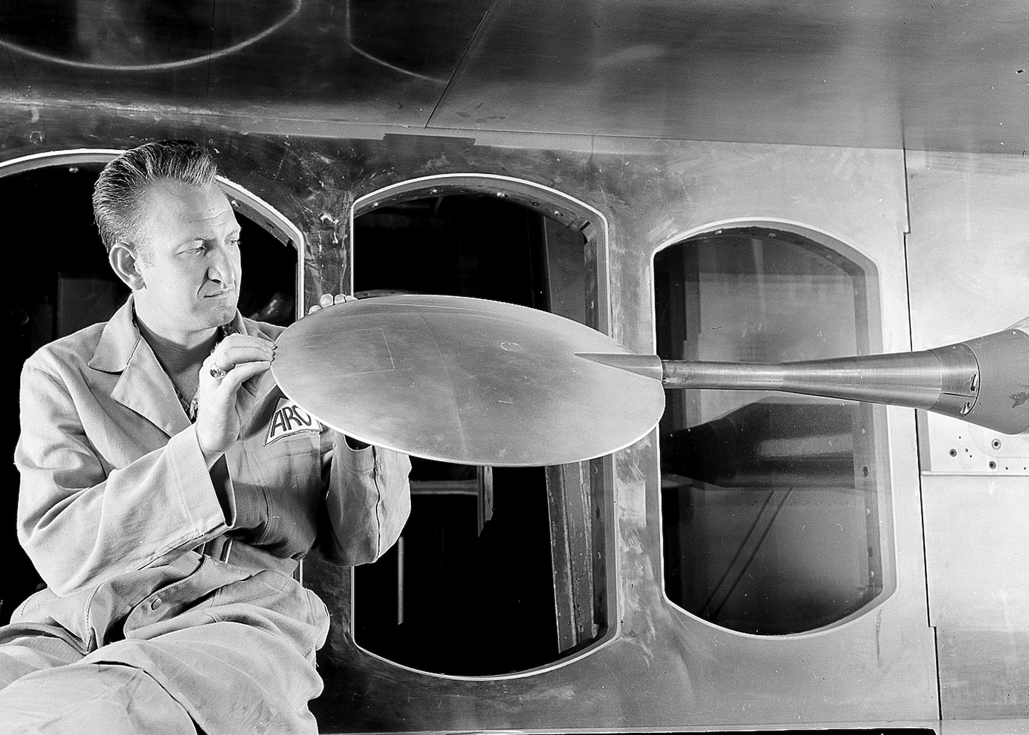 An Arnold Research Organization technician examines the Pye Wacket, an experimental lenticular-shaped air-to-air rocket developed by Convair, in a tunnel of the von Kármán Gas Dynamics Facility at the Arnold Engineering Development Center in 1959. ARO was the first company awarded a contract to operate AEDC. The contract between ARO and the Air Force was signed June 29, 1950. (U.S. Air Force photo)