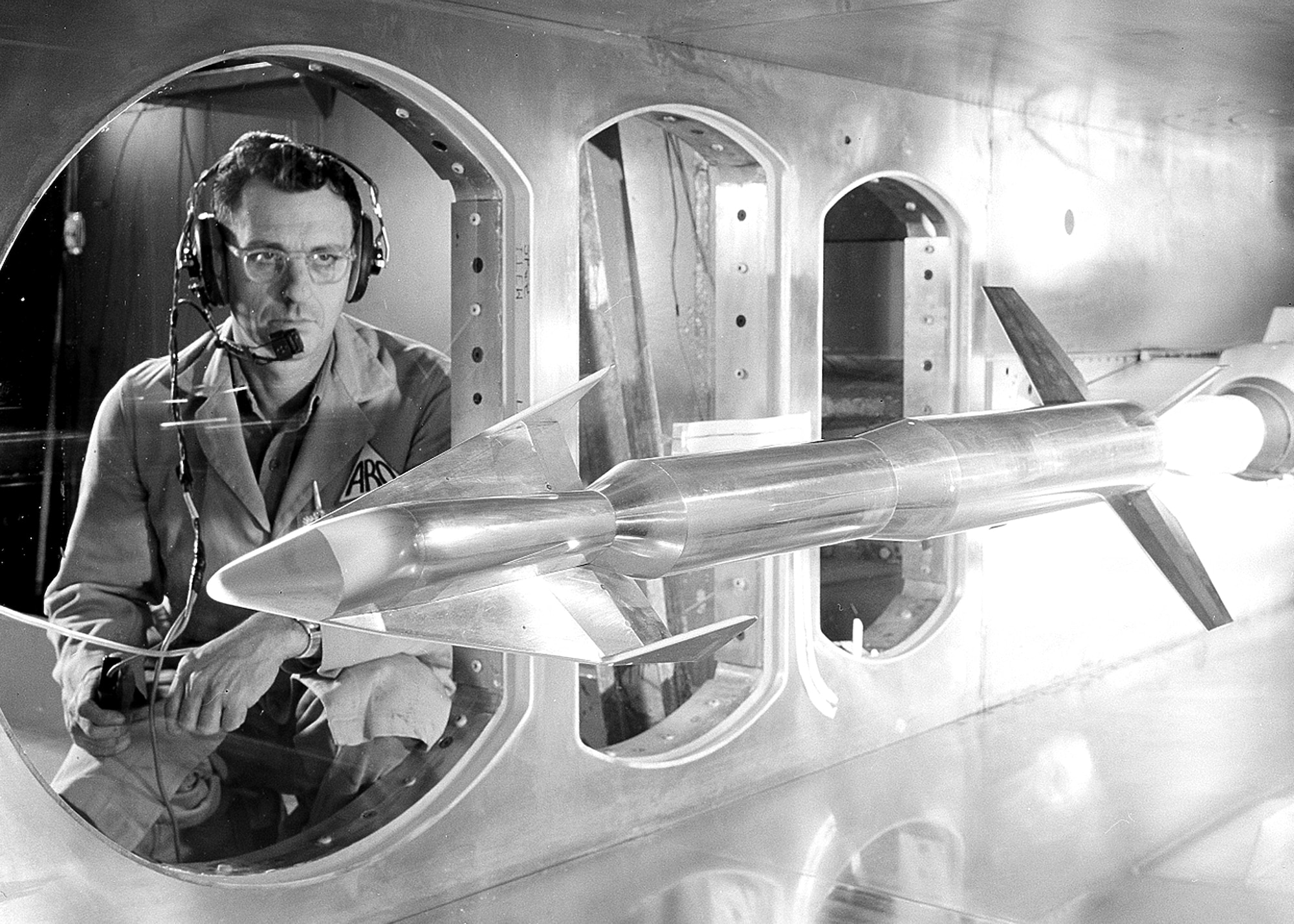 An Arnold Research Organization technician examines a model of the Dyna-Soar, a planned space plane being developed, in an Arnold Engineering Development Center wind tunnel in 1961. ARO was the first company awarded a contract to operate AEDC. The contract between ARO and the Air Force was signed June 29, 1950. (U.S. Air Force photo)