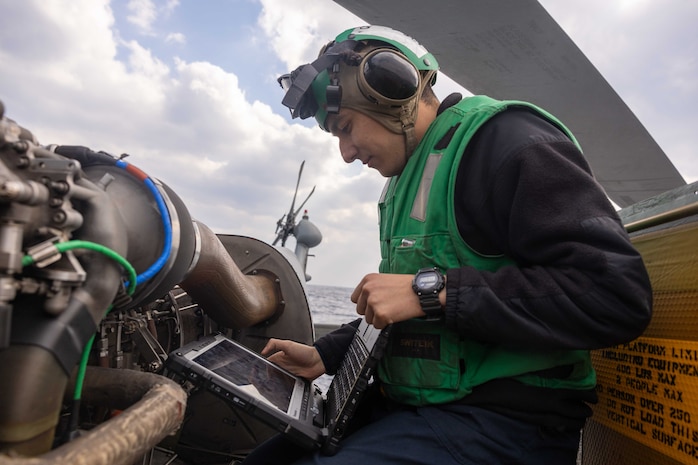 Aviation Electrician's Mate 2nd Class Benjamin Reyes, from San Diego, assigned to Helicopter Maritime Strike Squadron (HSM) 51, references a technical manual during an engine maintenance check of an MH-60R Sea Hawk on the flight deck of the Arleigh Burke-class guided-missile destroyer USS Preble (DDG 88) in the East China Sea, Jan. 29.  (U.S. Navy photo by Mass Communication Specialist 1st Class Ryre Arciaga)
