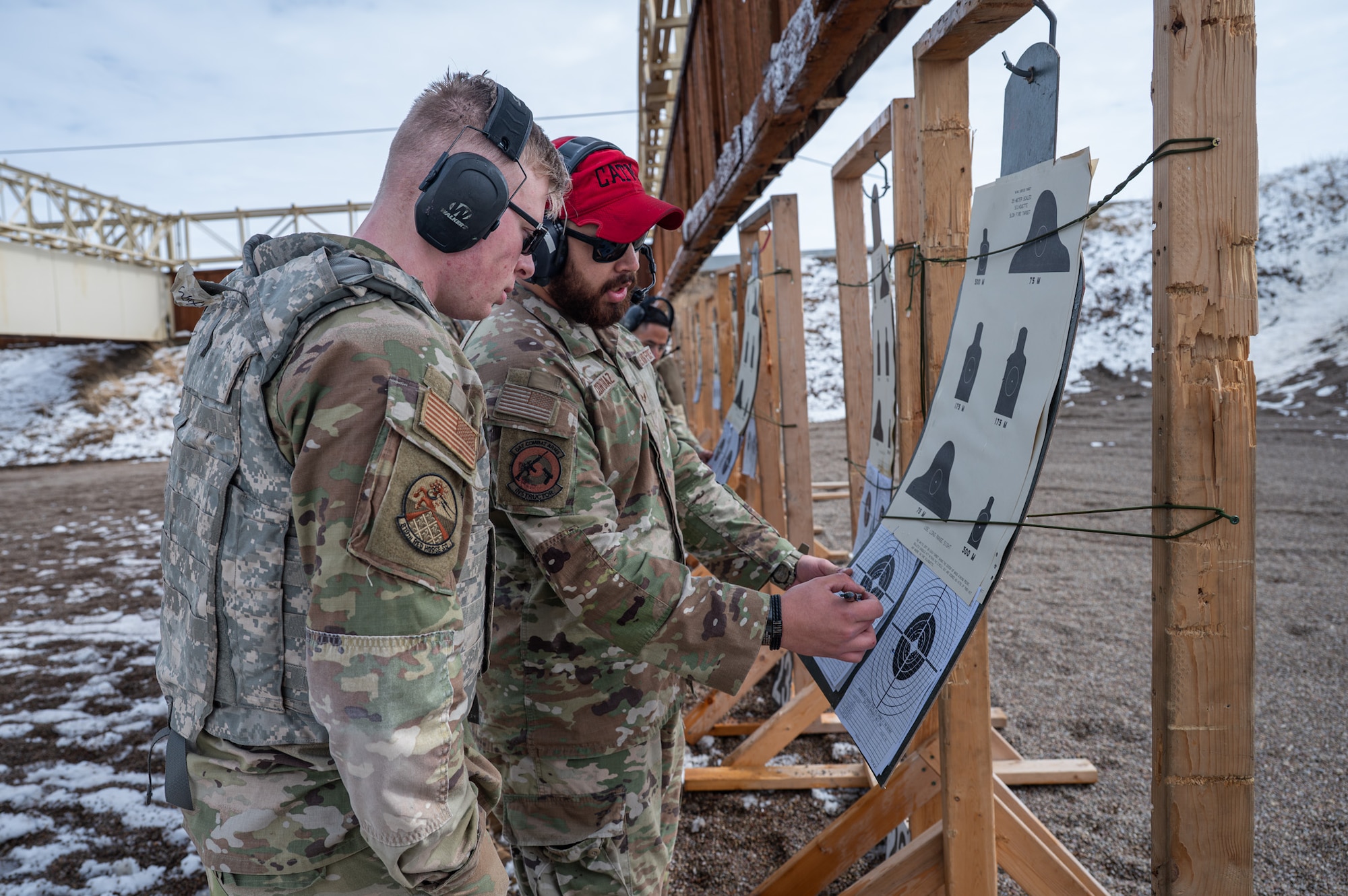 Two uniformed men reviews a firing target.