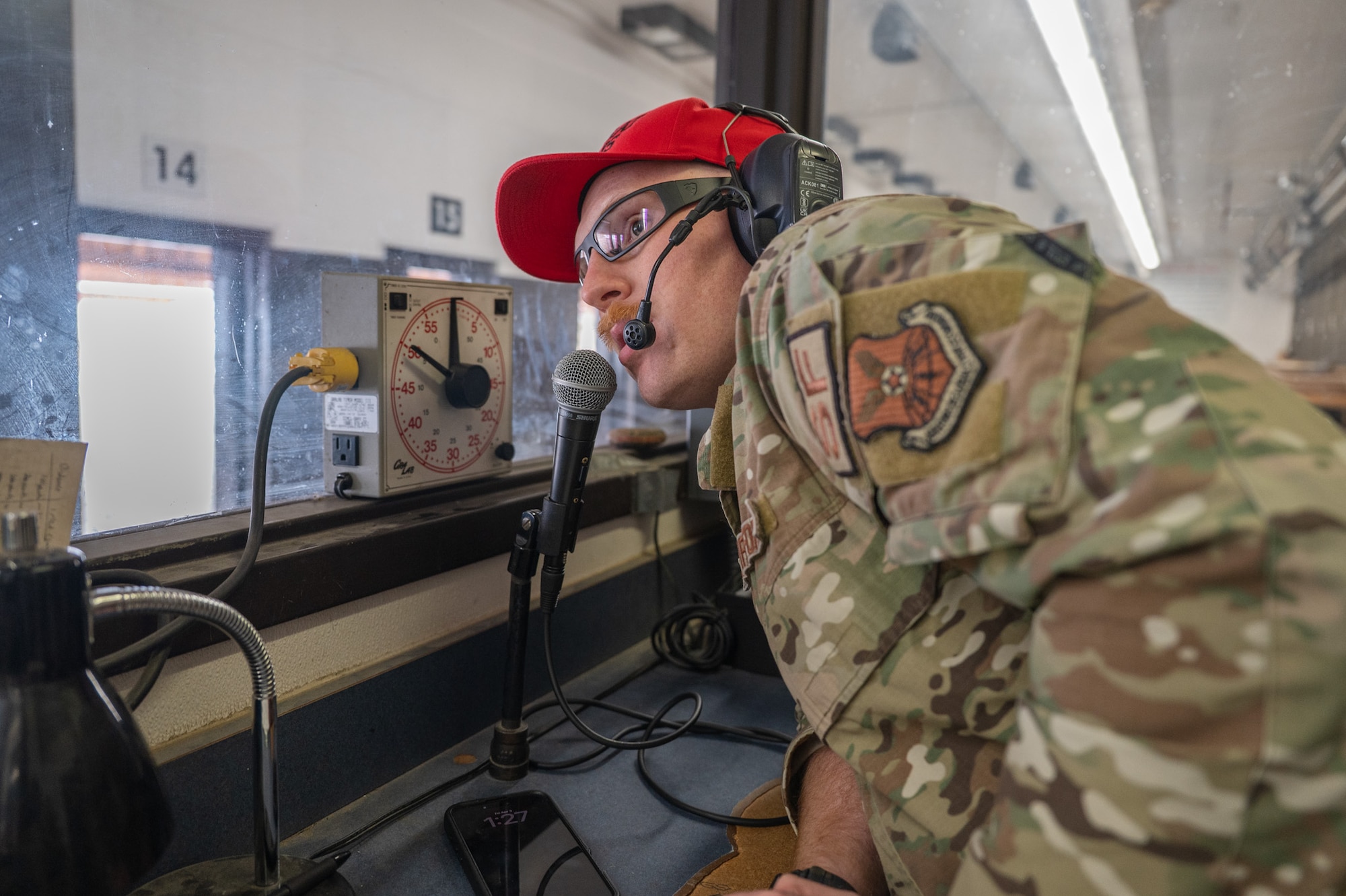A uniformed man speaks into a microphone.