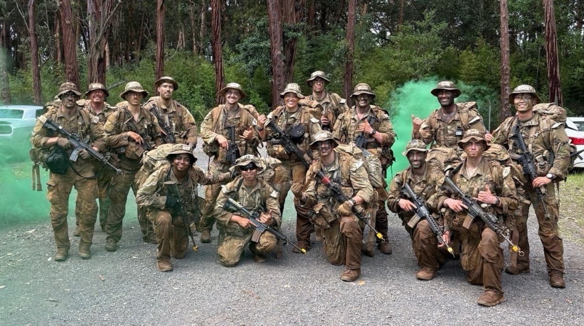 Service members pose for a group photo during a training exercise.