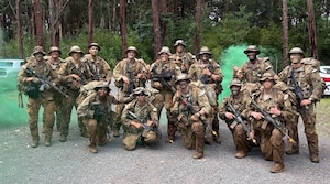 Service members pose for a group photo during a training exercise.