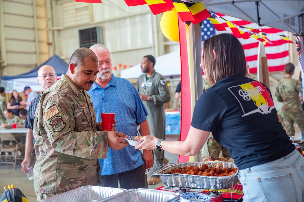 A U.S. Air Force Airman assigned to the 56th Fighter Wing receives traditional meatballs from a German service member’s spouse during International Day 2026, April 10, 2026, at Luke Air Force Base, Arizona.