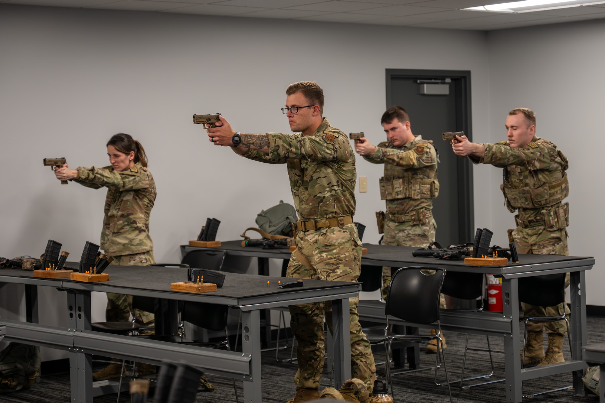 Uniformed personnel point firearms.