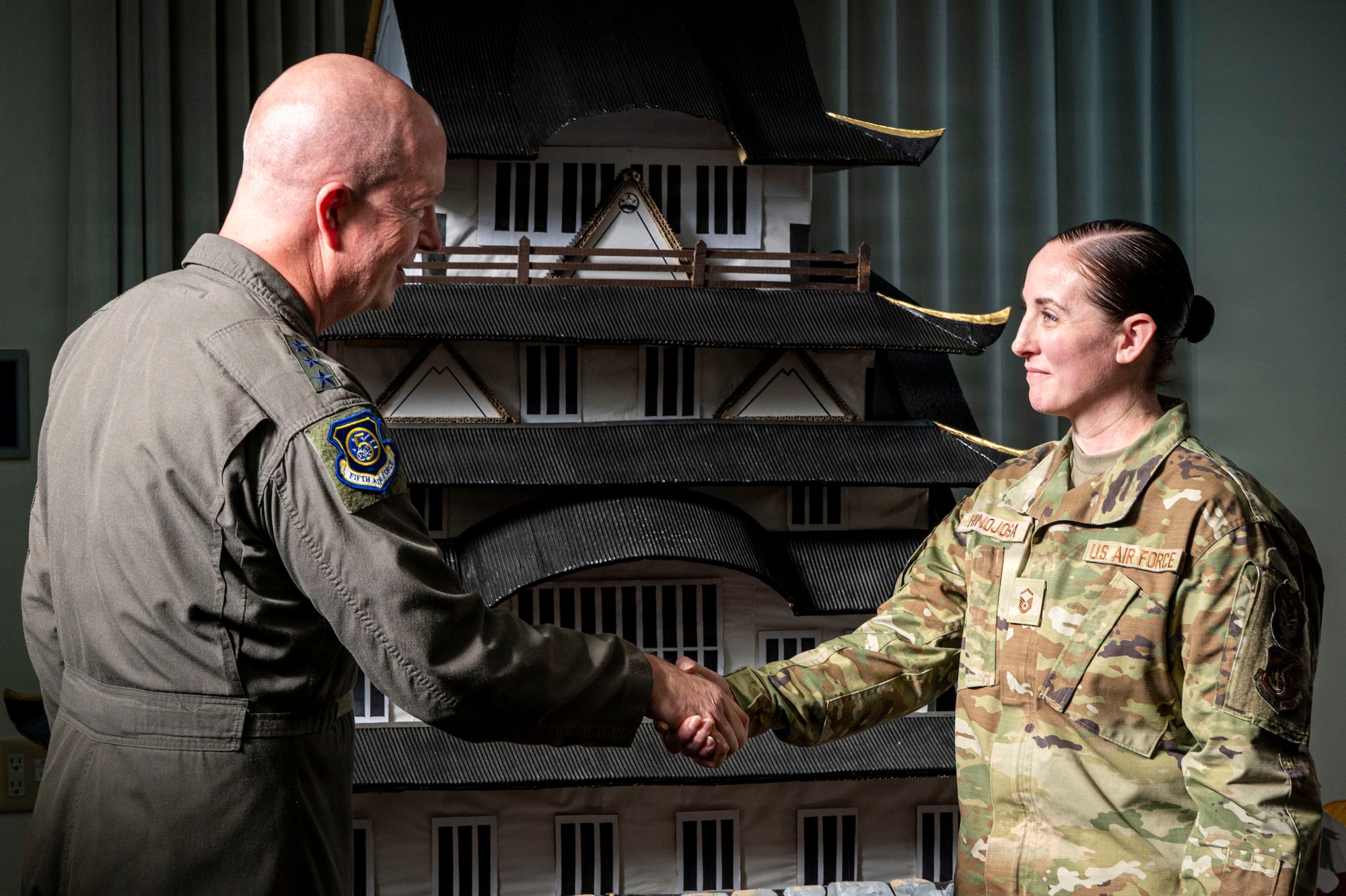 U.S Air Force Lt. Gen. Joel Carey, Fifth Air Force commander, presents a coin to Master Sgt. Sarah Hinojosa, 35th Fighter Wing inspections program manager, during a visit.