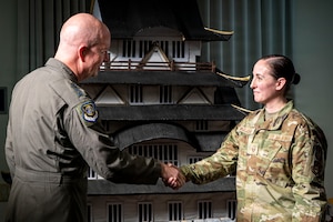 U.S Air Force Lt. Gen. Joel Carey, Fifth Air Force commander, presents a coin to Master Sgt. Sarah Hinojosa, 35th Fighter Wing inspections program manager, during a visit.