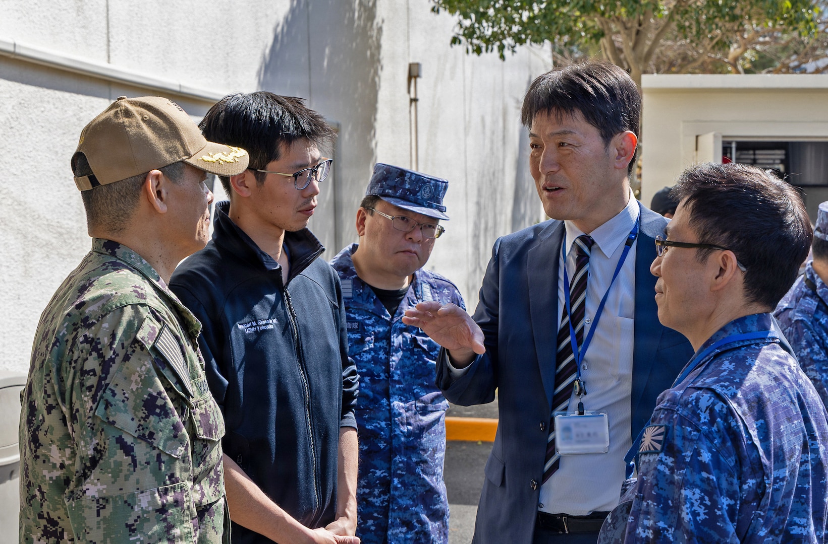YOKOSUKA, Japan (March 11, 2026) — Eiji Hinoshita, M.D., director general for health and medicine, Japan Ministry of Defense, speaks with Capt. Donavon YapShing, deputy director of U.S. Naval Hospital (USNH) Yokosuka, alongside Japan Maritime Self-Defense Force (JMSDF) personnel during a bilateral mass casualty drill at USNH Yokosuka. The engagement highlighted coordination between USNH Yokosuka and Japanese medical leaders to strengthen interoperability and operational readiness in the Indo-Pacific. USNH Yokosuka and Japan Self-Defense Force (JSDF) Hospital Yokosuka conducted the drill to enhance joint medical response capabilities and lifesaving procedures in support of a free and open Indo-Pacific. (U.S. Navy photo by Daniel Taylor/U.S. Naval Hospital Yokosuka Public Affairs)