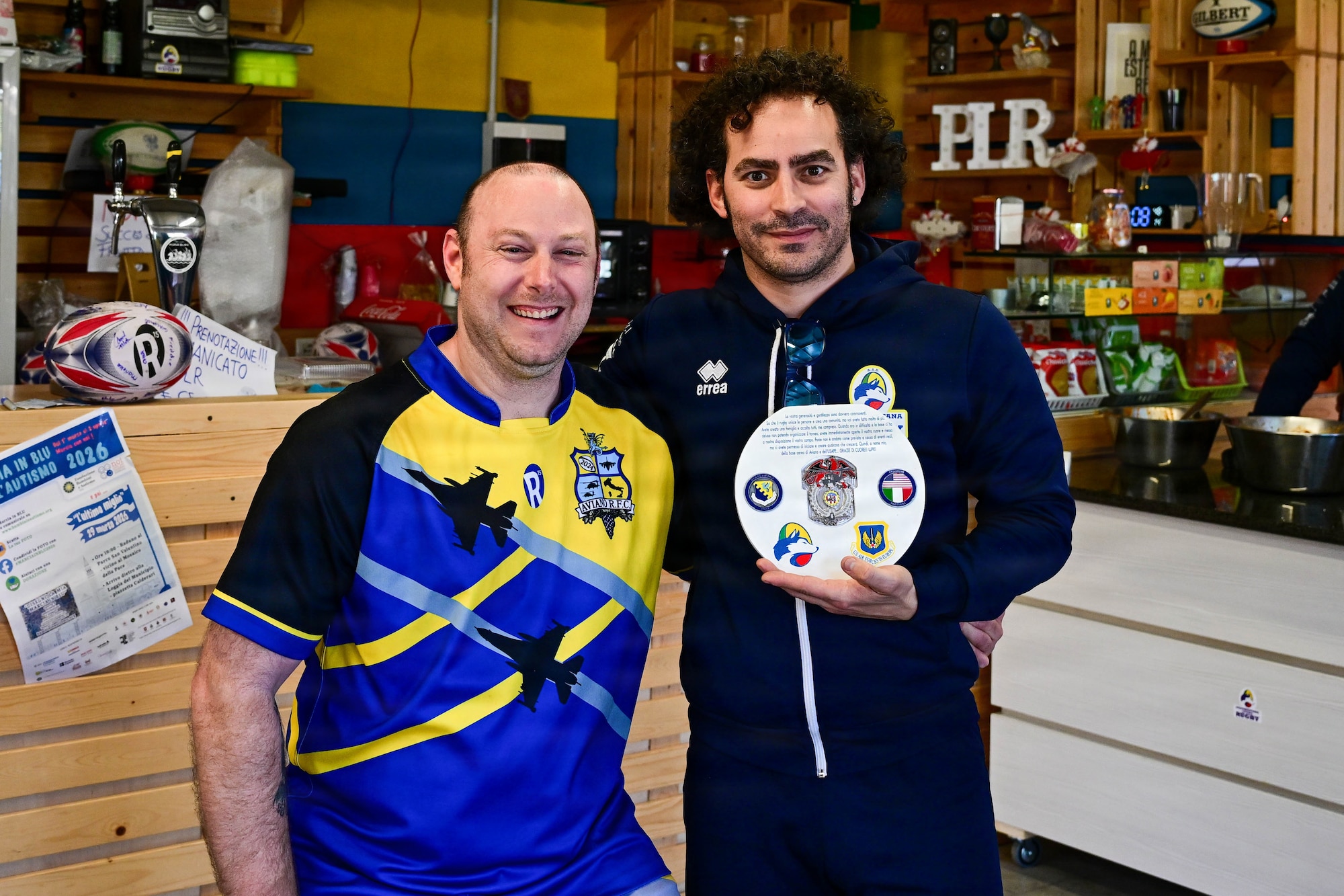 Rugby players holds an award.