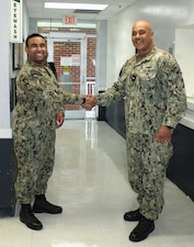 DAHLGREN, Va. – Rear Adm. Reginal Ewing, III, director, Defense Health Agency-National Capital Region, presents a coin to Hospital Corpsman 2nd Class Morales recognizing him for maintaining the laboratory's high standards during a four-month gap without a laboratory officer. Despite having only five years of service, Morales has demonstrated a rare balance of knowledge, skill, and diligence, with a technical expertise that has been compared to that of a more senior technician.