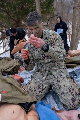 260212-N-JC800-1013 BETHESDA, Md. (Feb. 12, 2026) - Hospital Corpsman 2nd Class Richard Blair, assigned to the Na val Postgraduate Dental School at Naval Medical Leader and Professional Development Commmand, simulates readying a shot during a final exercise as part of the Tactical Combat Casualty Course. (U.S. Navy Photo by Mass Communication Specialist 1st Class Heath Zeigler/Released)