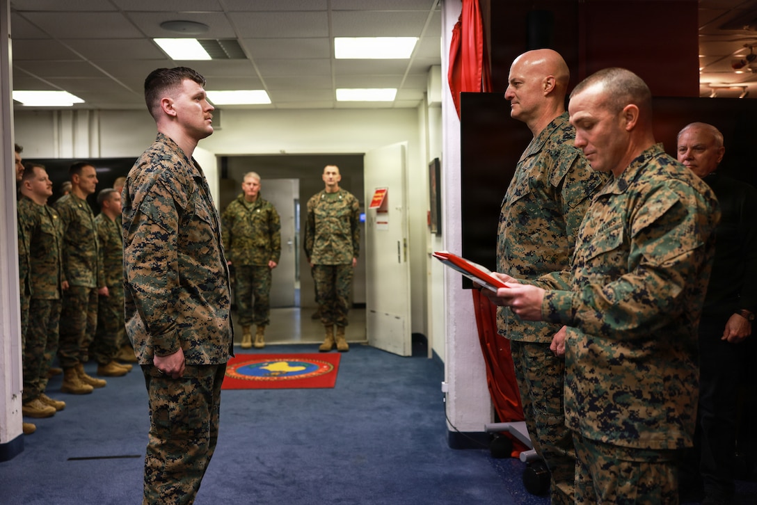 U.S. Marine Corps Sgt. Joshua Johnson, a ground command and control operations noncommissioned officer with U.S. Marine Corps Forces, Europe and Africa, stands at attention during the reading of his award citation at U.S. Army Garrison Panzer Kaserne, Stuttgart, Germany, Dec. 31, 2025. Johnson, a native of Wisconsin, was awarded the medal for his decisive response and lifesaving efforts after viewing a car crash on Dec. 24, 2024. While on annual leave, Johnson pulled the driver from her crashed vehicle and administered cardiopulmonary resuscitation until emergency medical services arrived. (U.S. Marine Corps photo by Cpl. Garrett Gillespie)