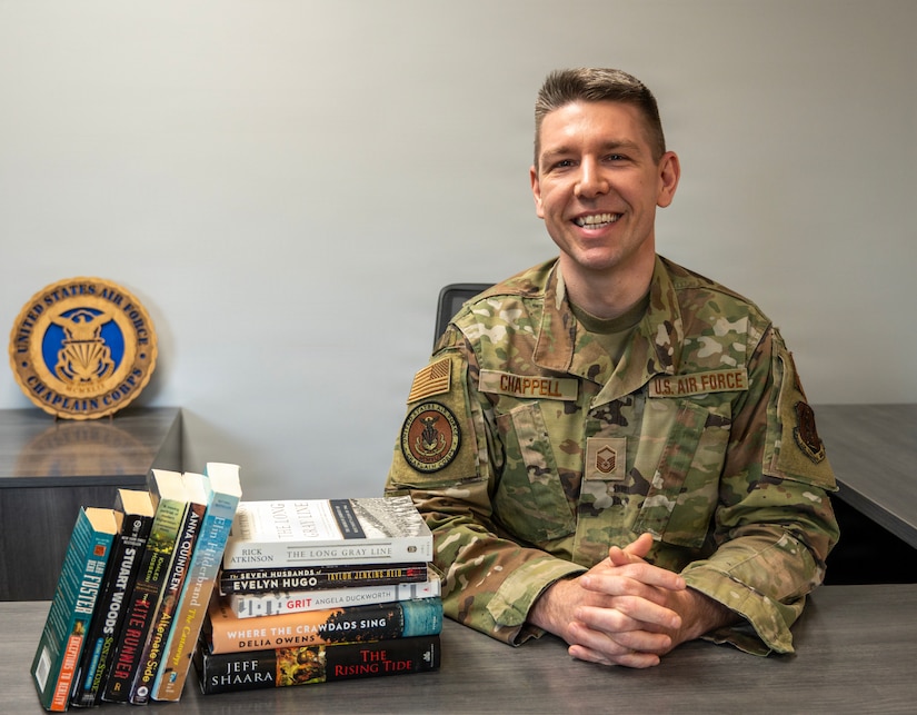 Master Sgt. Frank Chappell, religious affairs superintendent, 171st Air Refueling Wing, poses for a photo with books from the Little Free Library in the Resiliency Center, April 6, 2026, near Pittsburgh. Chappell initially received over 30 boxes of books from Operation Paperback, a non-profit organization that collects gently used books from volunteers and ships them to American troops, military families, and veterans. (U.S. Air National Guard photo by Airman 1st Class Natalie Claypoole)