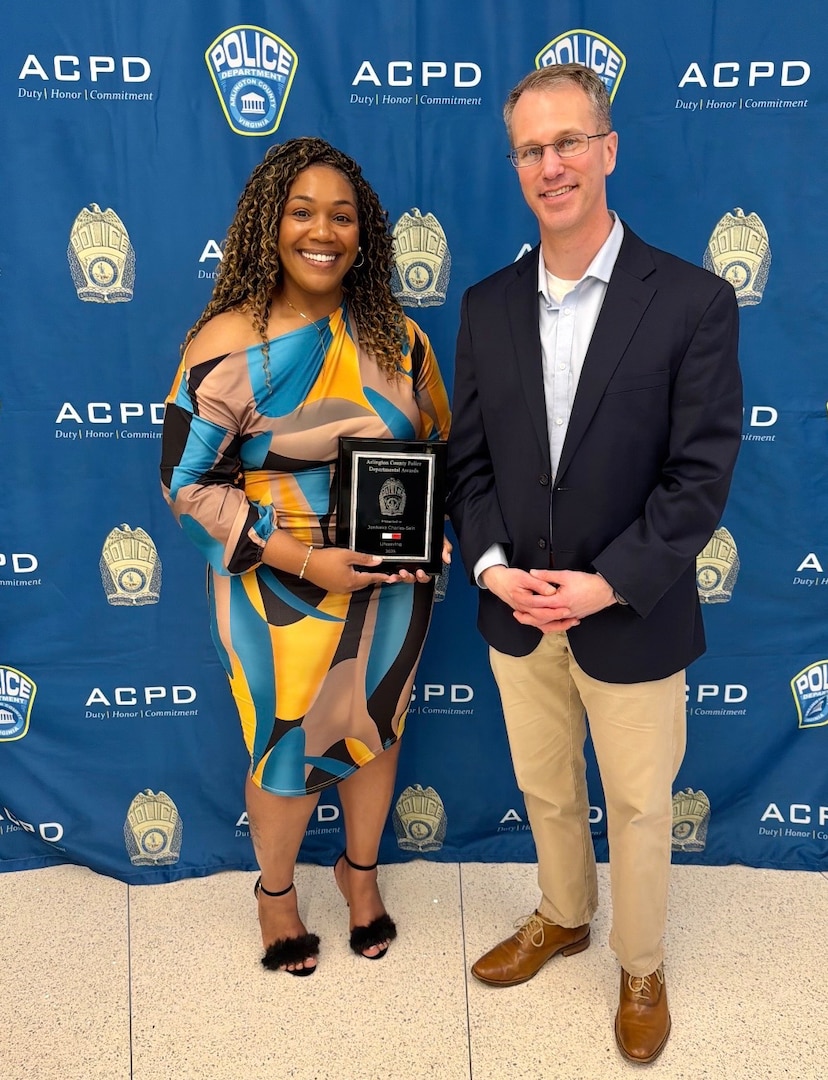 Male and female pose for photo after an award ceremony
