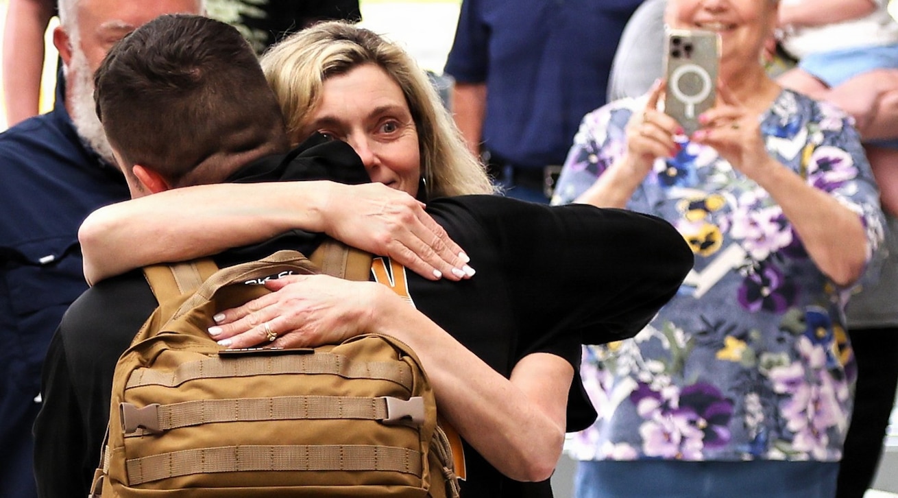 Tia Petersen hugs her son, Illinois Army National Guard Capt. Tucker Petersen, after his April 14 return from deployment