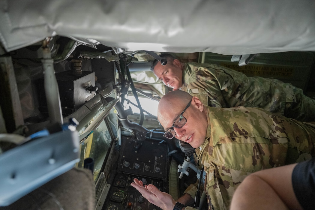 U.S. Air Force Tech. Sgt. Casey Lackie, 97th Training Squadron boom operator, lays in the boom pod of a U.S. Air Force KC-135 Stratotanker aircraft with Chief Master Sgt. Dennis Fuselier, 21st Air Force command chief and an Air Mobility Command (AMC) civic leader at Altus Air Force Base, Oklahoma, April 9, 2026. AMC senior leaders and civic leaders had the opportunity to tour the boom pod and cockpit of a KC-135. (U.S. Air Force photo by Airman 1st Class Emma Wright)
