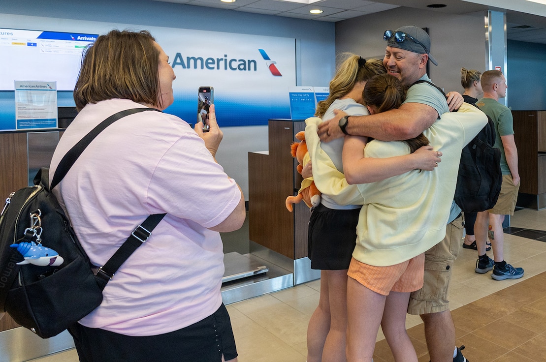 Sammye Geer, wife of Illinois Army National Guard Maj. Drew Geer, captures the moment daughters, Gracee, Paislee, and Parker Geer hug their father after his April 14 arrival at the Abraham Lincoln Capital Airport in Springfield.