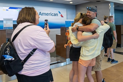 Sammye Geer, wife of Illinois Army National Guard Maj. Drew Geer, captures the moment daughters, Gracee, Paislee, and Parker Geer hug their father after his April 14 arrival at the Abraham Lincoln Capital Airport in Springfield.