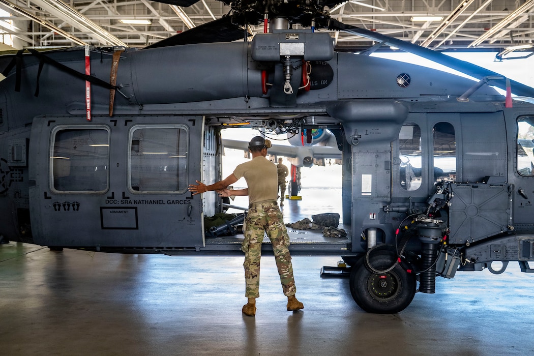 Airman closing the door of a HH-60W Jolly Green II.