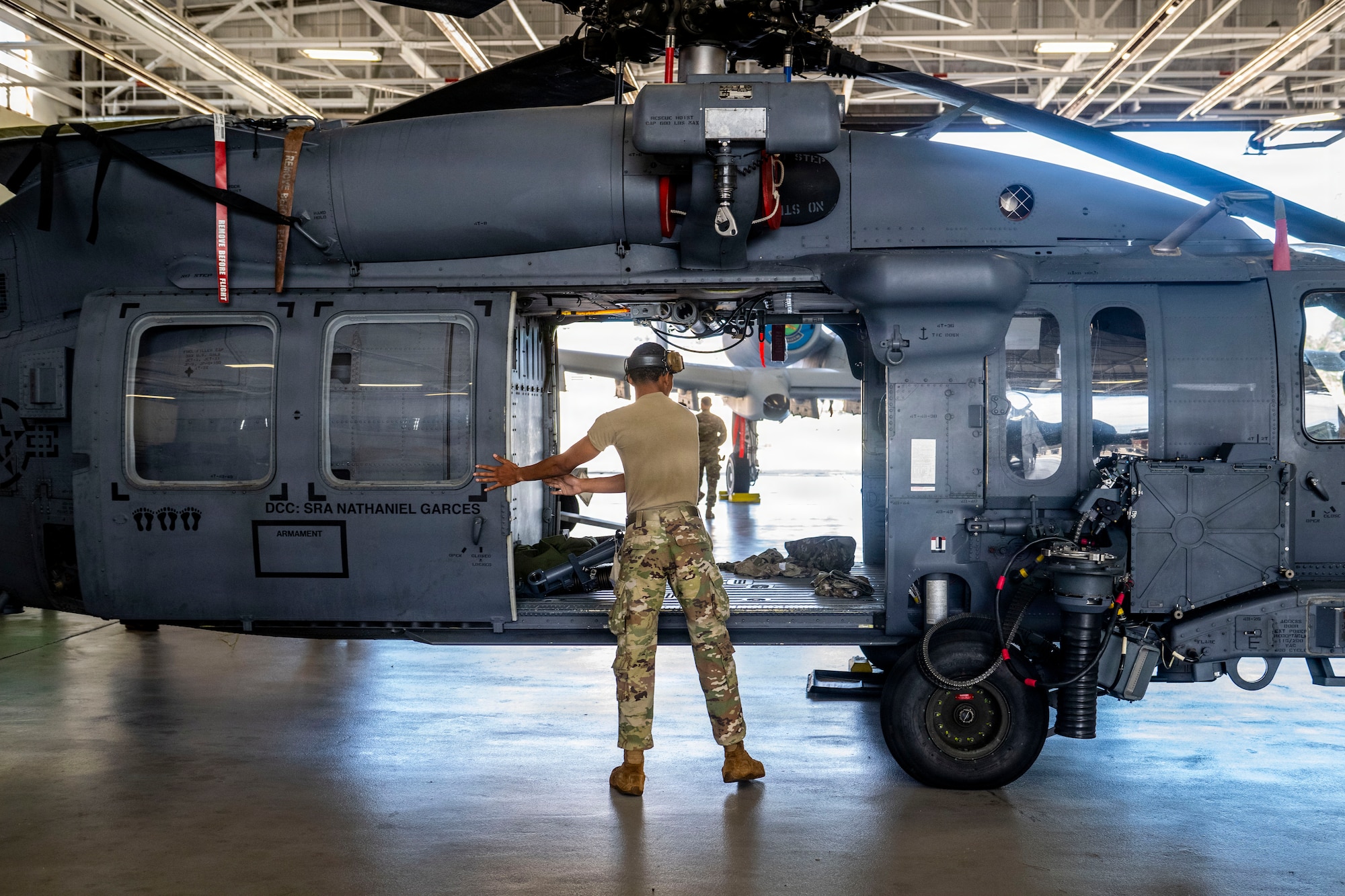 Airman closing the door of a HH-60W Jolly Green II.