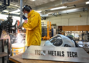Staff Sgt. Scott Estes, aircraft metals technology technician with the 113th Maintenance Squadron, grinds a piece of sheet metal at Joint Base Andrews, Md. on Mar. 20, 2026. The metals shop is a specialized fabrication team that repairs, designs, and manufactures metal parts for aircraft and a variety of equipment on base using precise welding and Computer Numerical Control (CNC) technology. (U.S. Air National Guard Photo by Staff Sgt. Natalie Filzen)