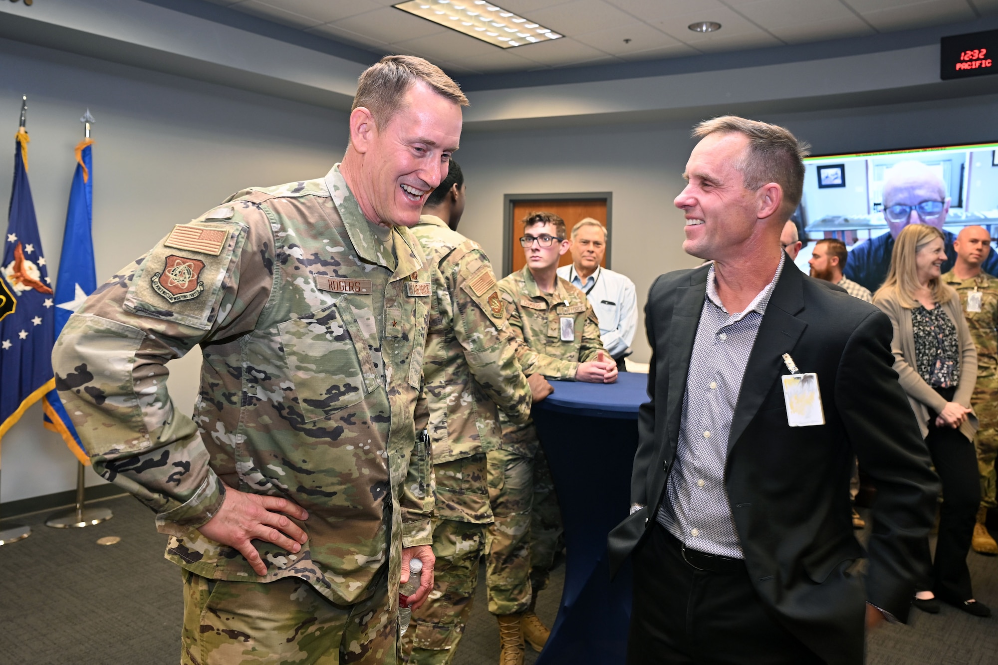 A man in uniform talks to a man in a suit