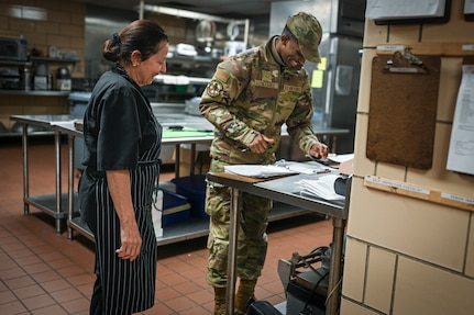 U.S. Air Force Airman 1st Class Mark Tolefree, public health technician with Bolling Medical Squadron Public Health, fills out a checklist during a food handling inspection with Mcdalia Luna, food service supervisor for the Bolling Club, Joint Base Anacostia-Bolling, Washington, D.C., April 1, 2026. The inspection focused on the elimination of preventable hazards across the JBAB community. (U.S. Air Force photo by Senior Airman Shanel Toussaint)