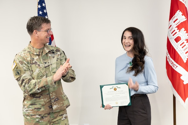 Man applauds near woman holding certificate