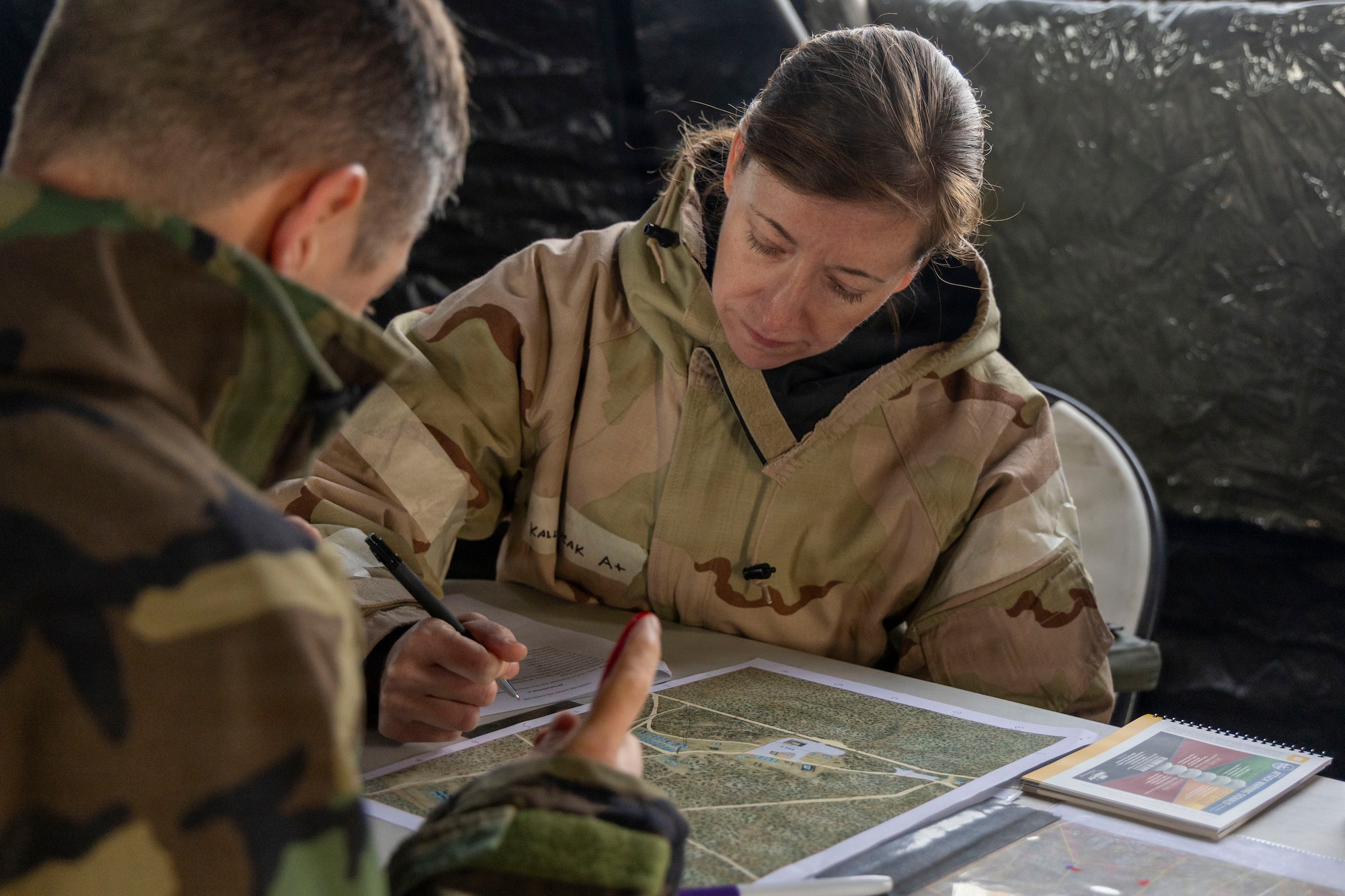 U.S. Air Force Lt. Col. Kallyn Harerncak, 412th Medical Group, marks a map during a chemical, biological, radiological, and nuclear threats defense exercise at Edwards Air Force Base, California, March 30, 2026. More than 250 Airmen from across different Air Force Career Codes throughout Edwards underwent CBRN defense validation over the a three day period. (U.S. Air Force photo by Jennifer Healy)