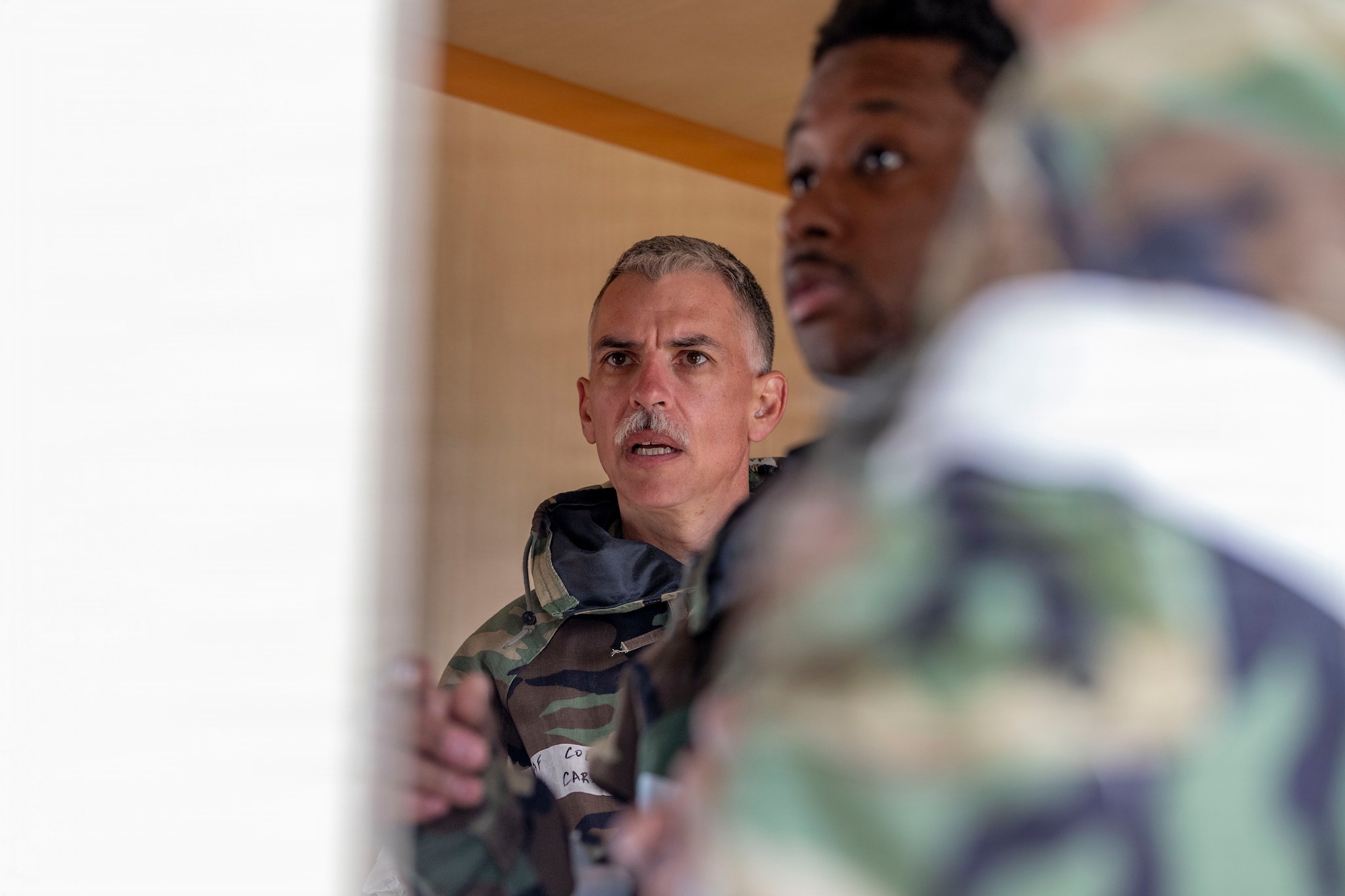 U.S. Air Force Col. Christopher Carnduff, left, commander, 412th Mission Support Group, listens to a briefing as part of a chemical, biological, radiological, and nuclear threats defense exercise at Edwards Air Force Base, California, March 30, 2026. The 812th Civil Engineer Squadron's Office of Emergency Management validated more than 250 Airmen over a three-day period in late March. (U.S. Air Force photo by Jennifer Healy)