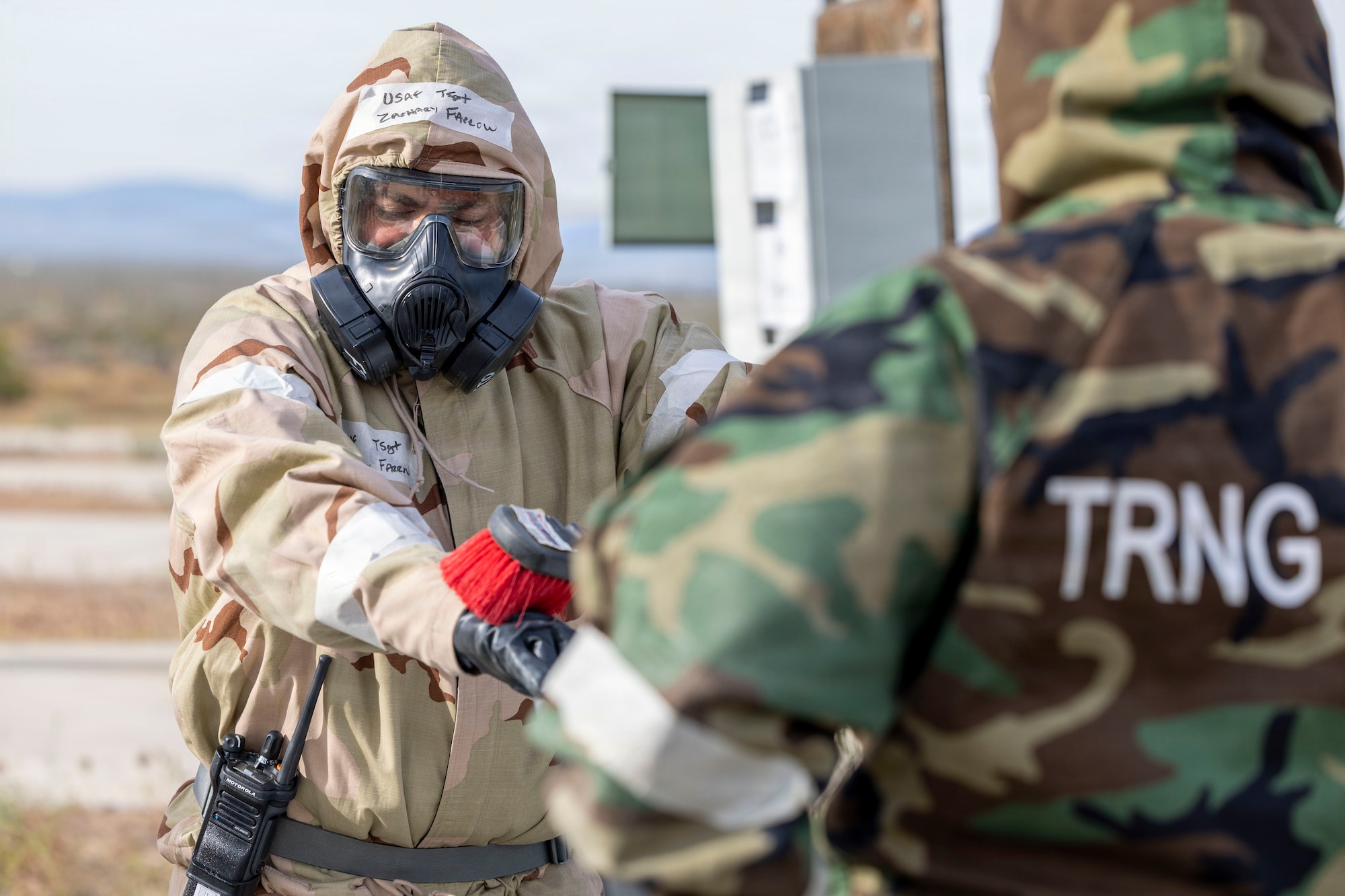 U.S. Air Force Tech. Sgt. Zachary Farrow, egress systems evaluator, 912th Aircraft Maintenance Squadron, conducts a simulated decontamination as part of a chemical, biological, radiological, and nuclear threats defense exercise at Edwards Air Force Base, California, March 30, 2026. The 812th Civil Engineer Squadron's Office of Emergency Management validated more than 250 Airmen over a three-day period in late March. (U.S. Air Force photo by Jennifer Healy)
