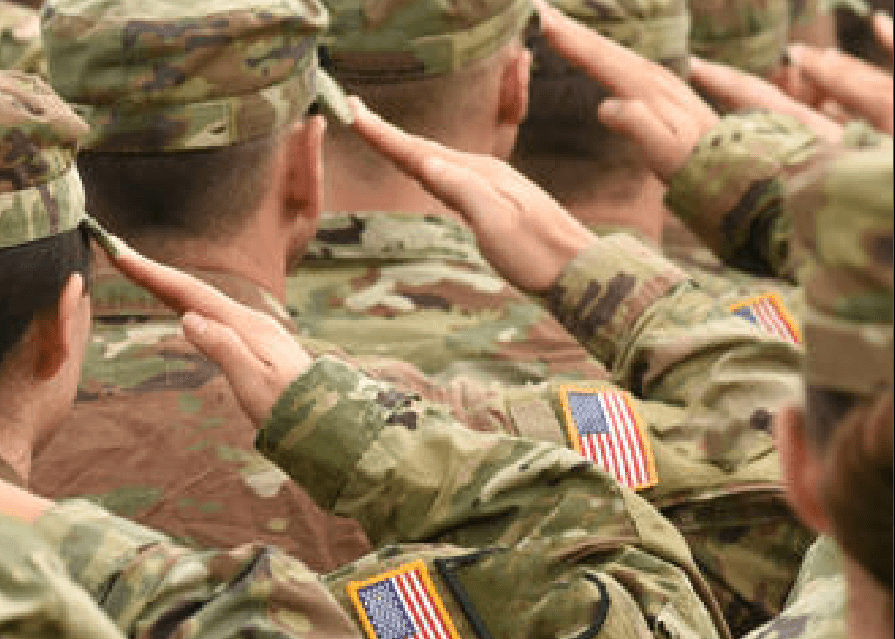 a photo of uniformed service members saluting. The photo angle is from behind the soldiers.