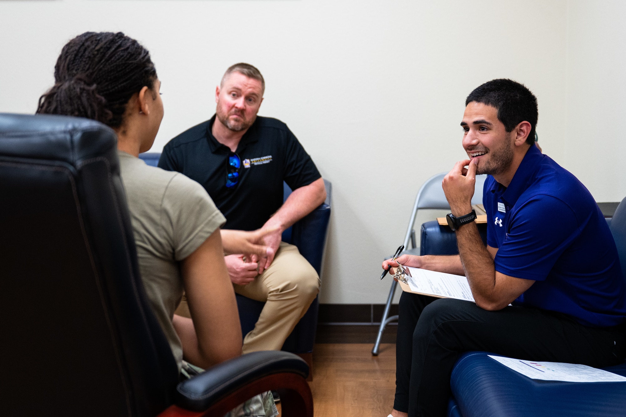 Joe McCormick, right, Hardin-Simmons University physical therapy associate professor, and Reece Martinez, HSU physical therapy student, center, review the musculoskeletal history of a U.S. Airman during a collaborative training event with the 7th Medical Group at Dyess Air Force Base, Texas, April 10, 2026. These assessments help identify performance limitations and inform individualized recovery plans. (U.S. Air Force photo by Senior Airman Jade M. Caldwell)