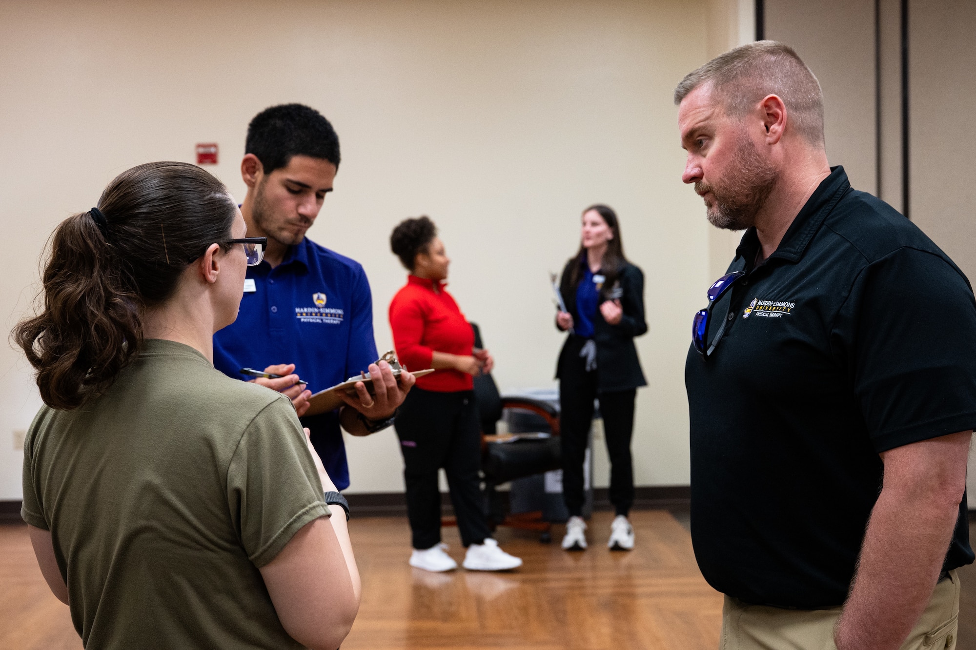 From left, a U.S. Airman discusses musculoskeletal pain history with Reece Martinez, Hardin-Simmons University physical therapy student, and Joe McCormick, HSU physical therapy associate professor, during a collaborative training event with the 7th Medical Group at Dyess Air Force Base, Texas, April 10, 2026. Participants were paired with Airmen and students to assess movement and guide group exercise recommendations. (U.S. Air Force photo by Senior Airman Jade M. Caldwell)