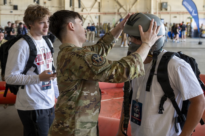 An Airman from the 171st Air Refueling Wing helps a student try on an aircrew helmet at the 171st Air Refueling Wing during an All-Star Leadership Day in Pittsburgh, Pennsylvania, April 15, 2026. Airmen shared their experiences and perspectives, encouraging students to consider leadership roles and STEM-focused careers within the U.S. Air Force. (U.S. Air National Guard photo by Tech. Sgt. Zoe M. Wockenfuss)