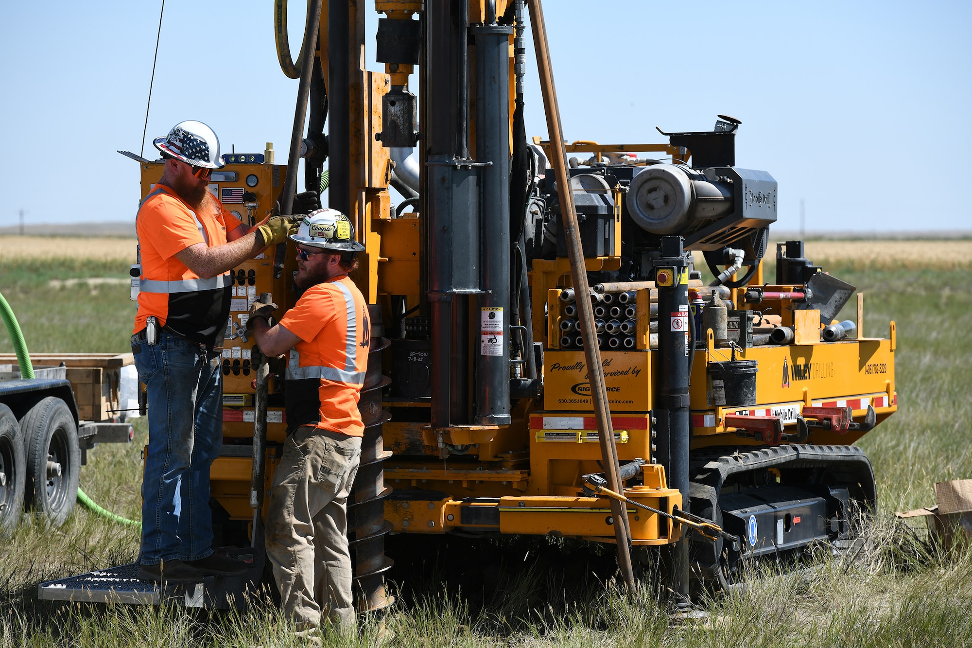 Mobile drilling rig operators collect a soil sample.