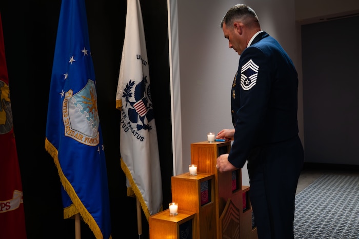U.S. Air Force CMSgt. Mike Nalley, 312th Training Squadron senior enlisted advisor, lights the final candle during the Candle Lighting for the Chief Recognition Ceremony.