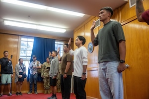Eleven Delayed Entry Program members are sworn in as family members look on during an Oath of Enlistment ceremony at the Joint Base Pearl Harbor-Hickam Military Entrance Processing Station in Honolulu, Hawaii, April 13, 2026. U.S. Air Force Brig. Gen. Jeffrey W. Nelson, commander of Air Force Recruiting Service, administers the oath to new Air Force recruits as part of his tour of the Pacific Air Forces. (U.S. Air Force photo by Senior Airman Aden Brown)