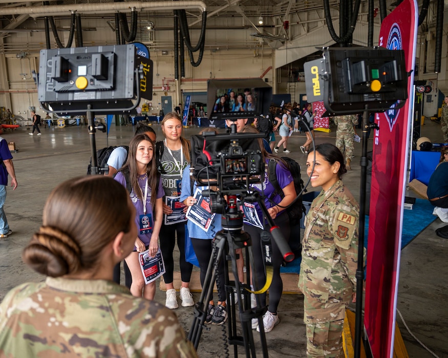 Students practice a news broadcast at the 171st Air Refueling Wing public affairs display table during an All-Star Leadership Day in Pittsburgh, Pennsylvania, April 15, 2026. Airmen shared their experiences and perspectives, encouraging students to consider leadership roles and STEM-focused careers within the U.S. Air Force. (U.S. Air National Guard photo by Tech. Sgt. Zoe M. Wockenfuss)