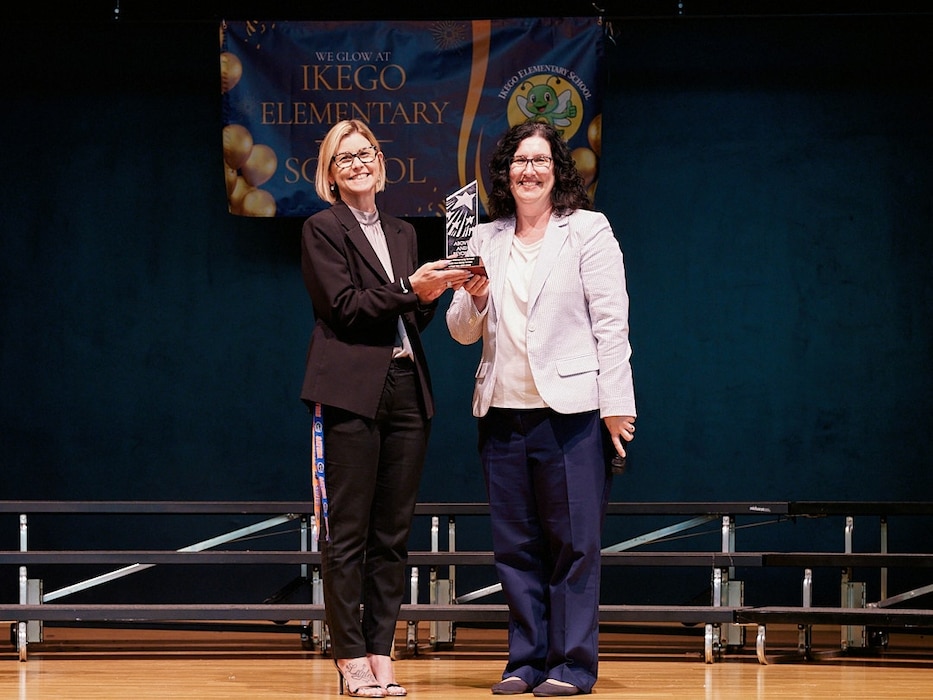 IKEGO HILLS FAMILY HOUSING AREA, Japan (April 14, 2026) -- Stacey Hull-Walsh, Ikego Elementary School principal, is presented the Stellar School Award by Dr. Jackie Ferguson, Department of War Education Activity (DOWEA) Pacific East District Superintendent, at a school assembly April 14, 2026 in Zushi, Japan. Ikego Elementary is the first DOWEA Pacific East school to earn the Stellar Schools Award. The award recognizes schools that demonstrate measurable impact in academic achievement, resilience, and well-being through strategic actions aligned to agency goals for every student, every day, everywhere as part of the DOWEA Blueprint for Continuous Improvement. (U.S. Navy photo by James Kimber)