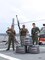 Coast Guard Helicopter Interdiction Tactical Squadron (HITRON) aircrew personnel aboard Coast Guard Cutter Midgett (WMSL 757) stand on the flight deck, displaying airborne use of force weapons from behind three bullet-damaged outboard engine cowlings in the Eastern Pacific Ocean.