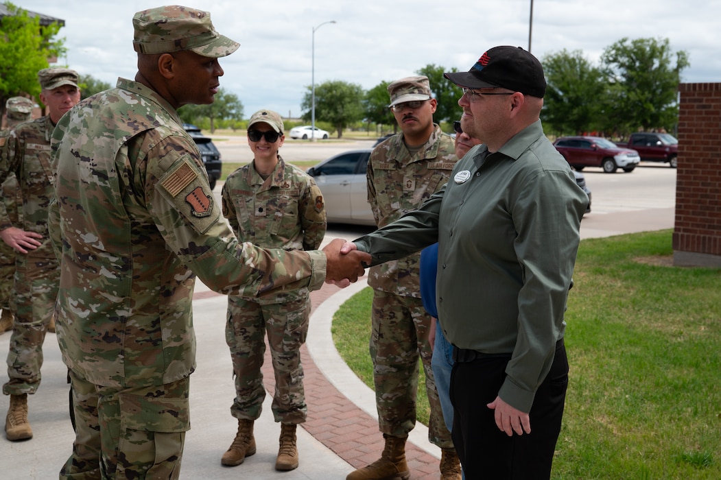 U.S. Air Force Maj. Gen. Roy W. Collins, Air Education Training Command deputy commander, coins Brian Stansburry, 17th Force Support Squadron employee, outside the Cressman Dining Facility at Goodfellow Air Force Base, Texas, April 10, 2026. Stansburry and the rest of the DFAC team were recognized for winning the John Hennessy Food Service Excellence Award. (U.S. Air Force photo by Senior Airman Brian Lummus)