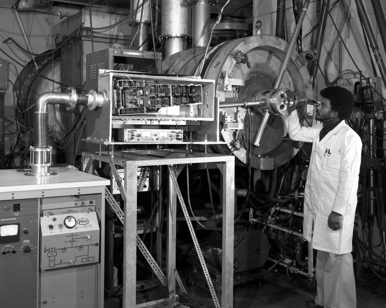 A U.S. Naval Research Laboratory technician operates a pulsed power experimental system in this archival image of the Gamble I, supporting early research into high-energy plasma behavior and laboratory simulation of space and fusion environments. The work contributed to foundational advances in plasma scence and national defense.