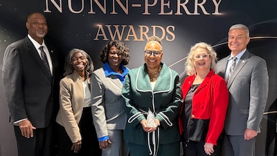 6 people in front of the Nunn Perry Award sign
